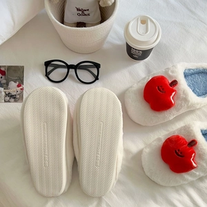 Vue détaillée de la semelle ondulée antidérapante et du design pomme en peluche
