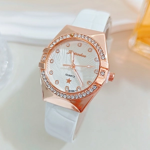 Macro shot of rose gold women's watch featuring rhinestone bezel and white leather strap