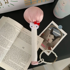 Hello Kitty themed pink satin massage hammer with white rope handle on a stylish desk