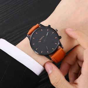 Business men's quartz watch with black round dial and brown leather strap on wrist