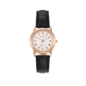 Detail of rose gold watch face with roman numerals and black embossed leather strap