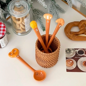 Creative bread-shaped ceramic spoons featuring croissant designs and cute smiley faces
