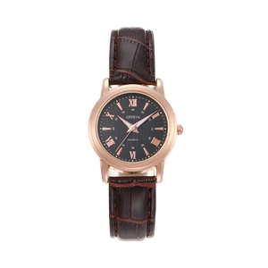 Detail of rose gold watch case with brown alligator leather strap and black Roman numeral dial