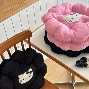 Detail of flower-shaped plush seat cushions featuring cute cartoon cat prints in pink and black