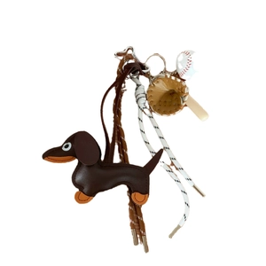 Brown leather dachshund bag charm with woven strap and baseball glove pendant accessories