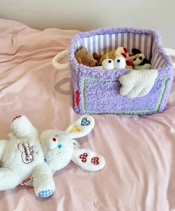 Detailed view of purple plush storage basket with white bunny doll on soft bedding