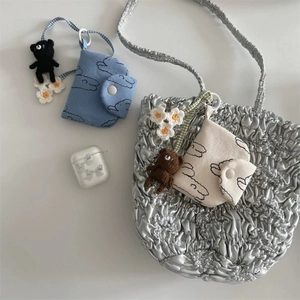 Gros plan du sac cabas plissé argenté avec pochette à fleurs et charms oursons