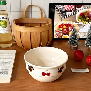 Süße cremefarbene Keramikschale mit Kirsch- und Dackelmuster auf einem Holztisch