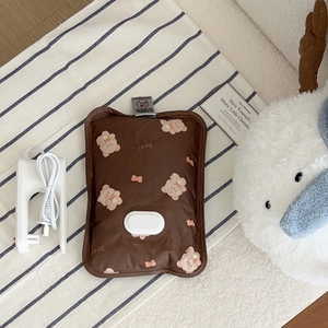Close-up of brown plush rechargeable hot water bottle with bear pattern and charging cable