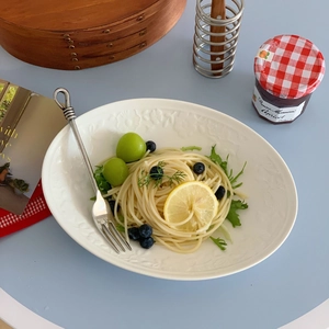 Vintage white ceramic oval plate with embossed floral edges featuring pasta and fruits