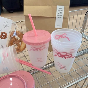 Transparante matte beker met rietje en roze strik decoratie in een metalen winkelmandje