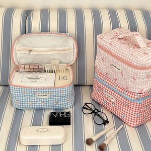 Internal mesh zipper pocket of the checkered bow makeup bag showing high capacity