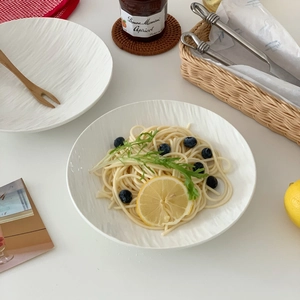 Detail of white ceramic dinner plates with spiral texture for pasta and salad