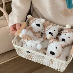 Close-up of plush Westie puppy keychains with Lovely tags in a vintage metal basket