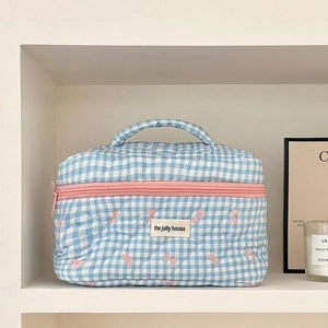 Detailed blue and white checkered quilted makeup bag with embroidered pink bows and handle