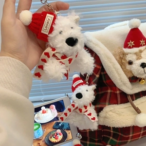 Close-up of white plush bear charms with red Christmas hats and heart scarves