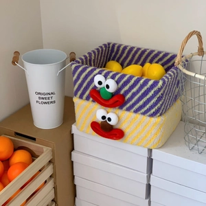 Detail of plush clown storage baskets in purple and yellow stripes for desk organization