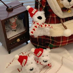 Detail of white plush Westie dog charm with red Christmas hat and heart scarf decor