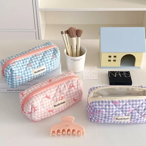 Quilted checkerboard pencil case and makeup bag with delicate bow embroidery in pastel colors
