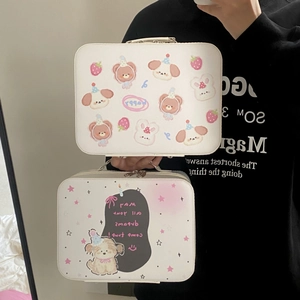 Detail van cartoon make-up koffers met beer- en puppyprints voorzien van handgrepen