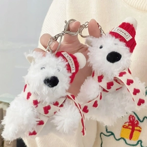 Close-up of white plush bear keychains with red knit hats and silver metal lobster clasps