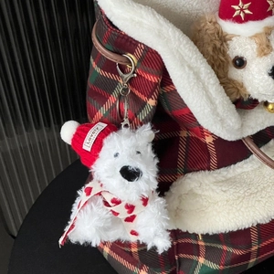 Mini white plush dog keychain with red knit hat and scarf on a plaid bag charm