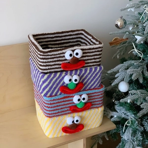 Set of four colorful striped lamb wool storage baskets with cute cartoon clown faces