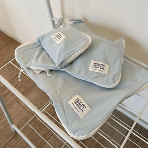 Light blue nylon travel organizer set of three bags on a white grid shelf