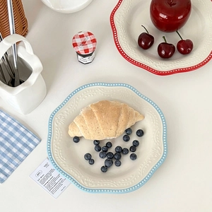 Flat lay of vintage embossed ceramic plates with blue and red polka dot wavy edges