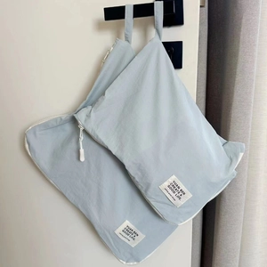 Light blue waterproof nylon travel storage bags set hanging on a door handle