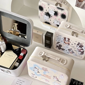 Detail of cream makeup case featuring cute animal illustrations and built-in vanity mirror