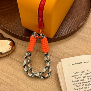 Detail of yellow silicone makeup bag showing durable zipper and braided lanyard connector