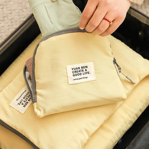 Travel luggage organizer set in light yellow nylon fabric being packed into a suitcase