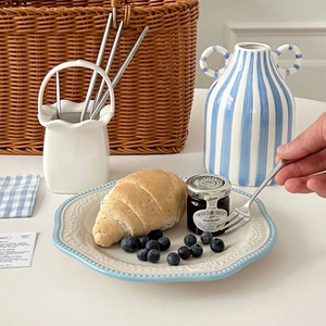 Close-up of retro ceramic plate with blue embossed edge featuring a fresh croissant