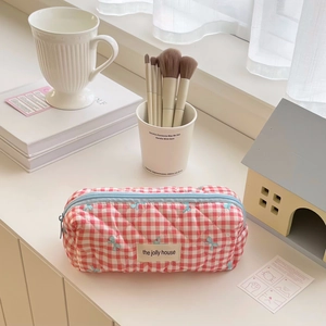Detail of red checkered quilted pencil case featuring the jolly house brand logo