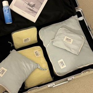 Waterproof travel organizer bag set in Morandi colors inside a silver suitcase
