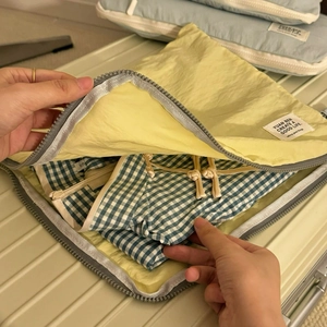 Waterproof light yellow travel luggage organizer bag with clothes for neat suitcase packing