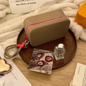 Detail of beige silicone cosmetic bag with pink zipper and braided rope handle