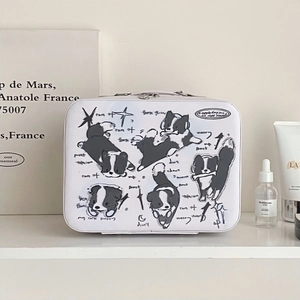 Detail view of a white vanity case featuring artistic black and white dog illustrations