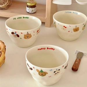 Detail of cream ceramic bowls with cute animal illustrations and wavy rim design