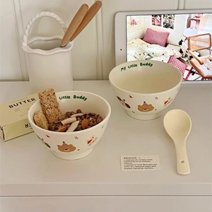 Detail view of two cream ceramic bowls with cute cartoon rabbit and bear illustrations