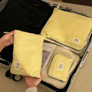Waterproof light yellow travel storage bags for clothes organized in a silver suitcase