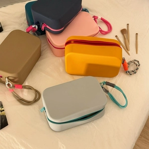 Close-up of portable silicone makeup bags in five colors with zipper and carabiner hooks