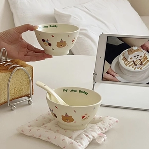Close-up of cute ceramic bowls with cartoon patterns, matching spoons and my little Buddy text