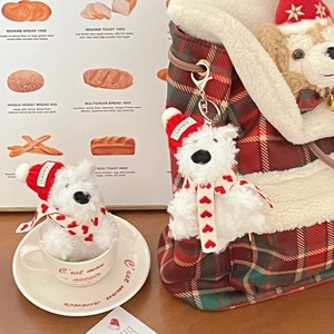 Mini plush Westie dog charm with red Christmas hat and scarf on a plaid canvas bag