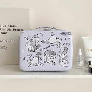 Detail of cartoon cat illustration and metal zippers on a large white makeup case