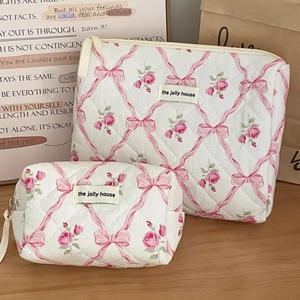 Détails de trousses de maquillage matelassées avec motifs de roses et étiquette de marque