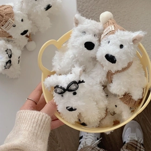 Close-up of cute white Westie plush keychains with hats and goggles in a basket