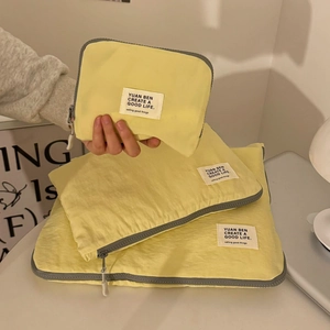 Three-piece yellow travel storage bag set for laptop, tablet, and cosmetics with gray edges