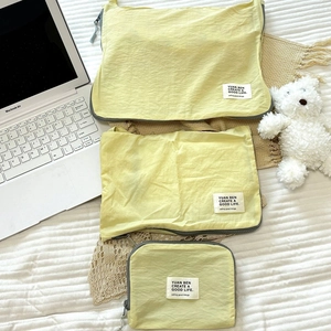 Three bright yellow travel storage bags in various sizes with waterproof nylon fabric